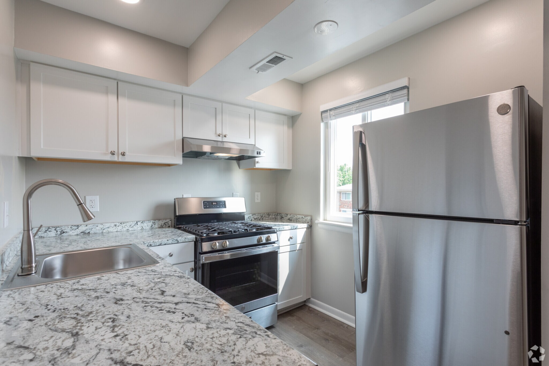 Updated kitchen with white cabinets and stainless appliances